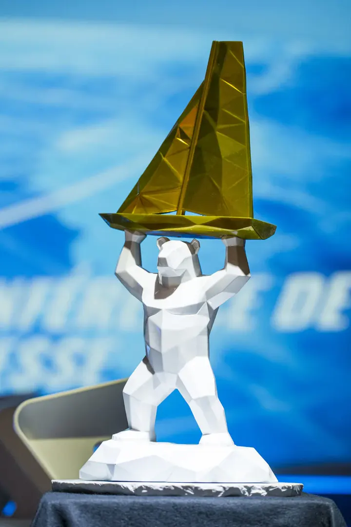 Le trophée de la Vendée Arctique 2026, un ours blanc à facettes portant un voilier doré, présenté sur scène
